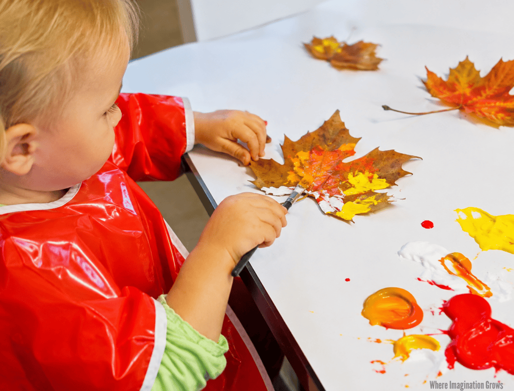 Fall Leaf Painting for Toddlers and Preschoolers Toddler painting real fall leaves with red yellow and orange paint