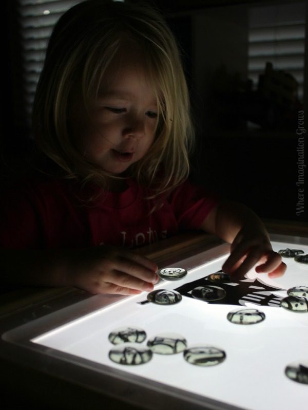 Child plays with DIY Halloween Story Stones on a Light Table 